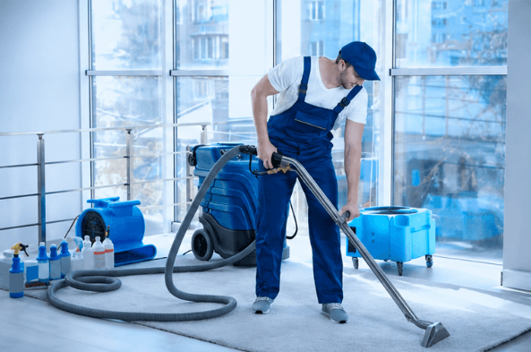 Agent effectuant une injection-extraction de moquette après travaux
